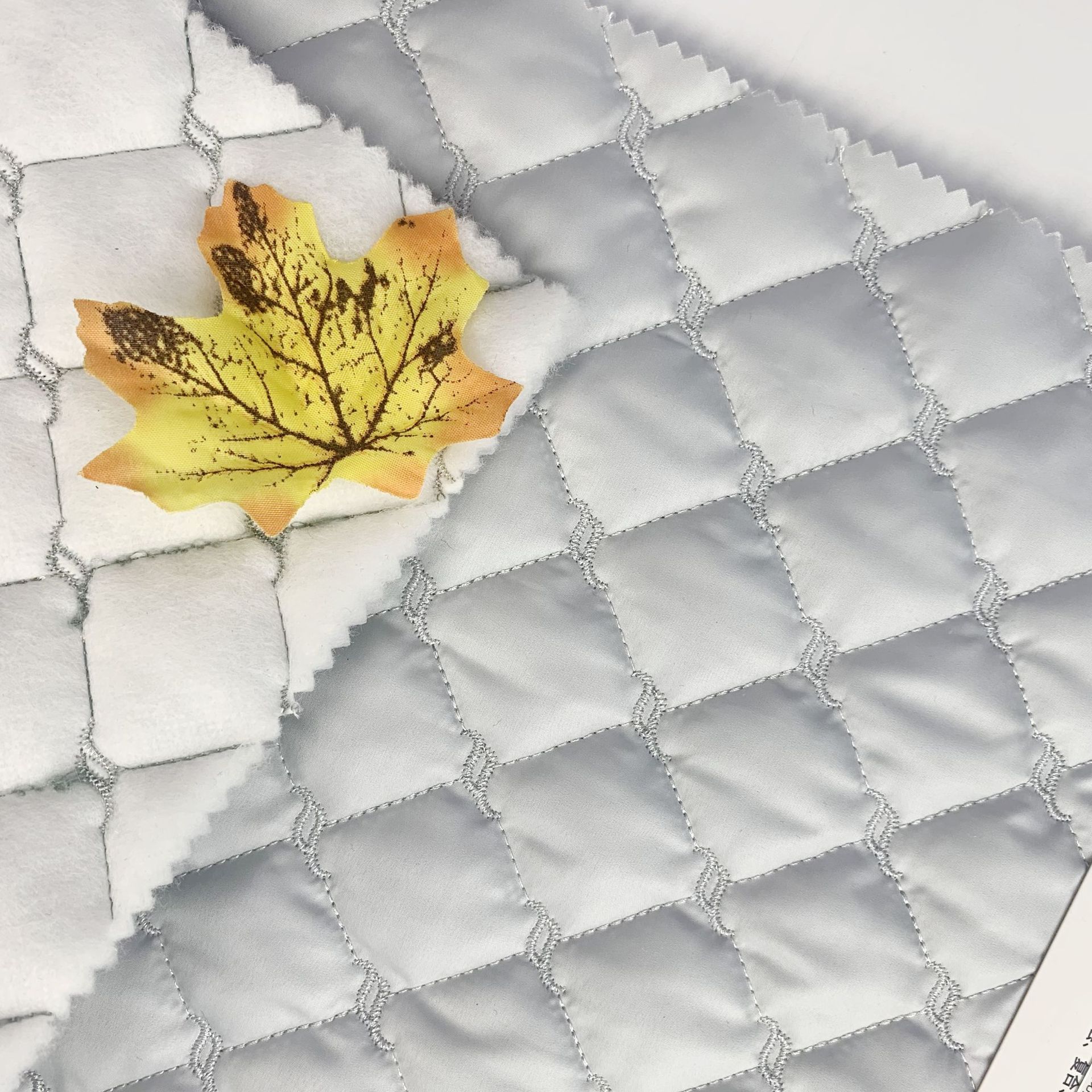 菱形格点缀水纹绗绣 秋冬夹棉面料 春亚纺童装棉服 绣花工厂